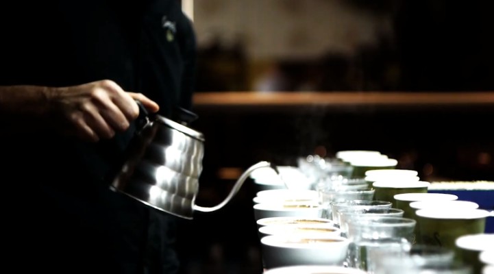 Pouring hot water into the coffee cups, ready to begin